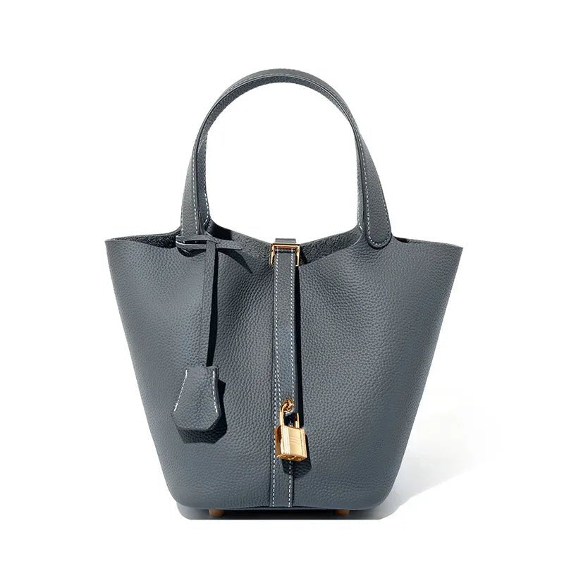 Gray handbag with a gold lock on a white background
