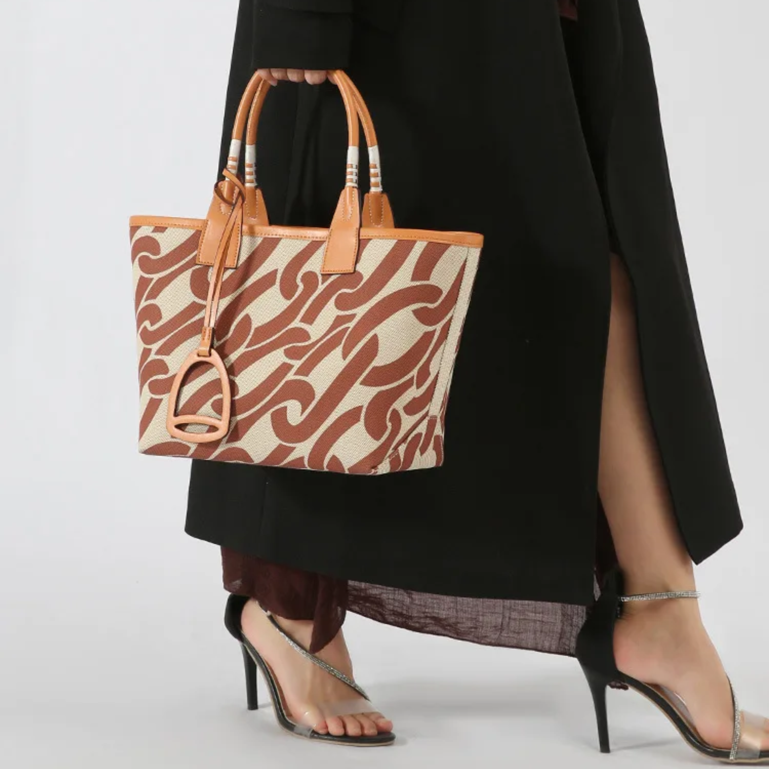 Person holding a patterned handbag with a plain background