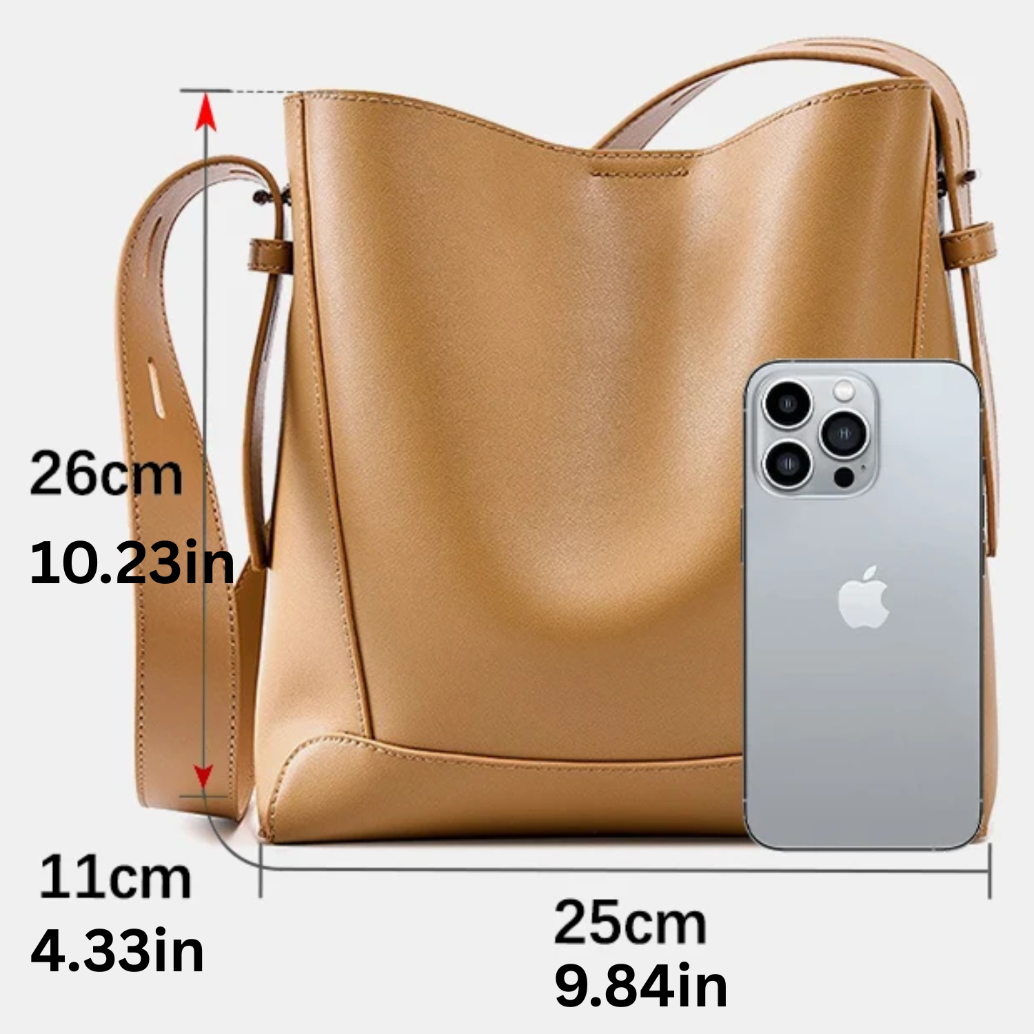 Brown handbag with measurements and an iPhone for scale on a white background