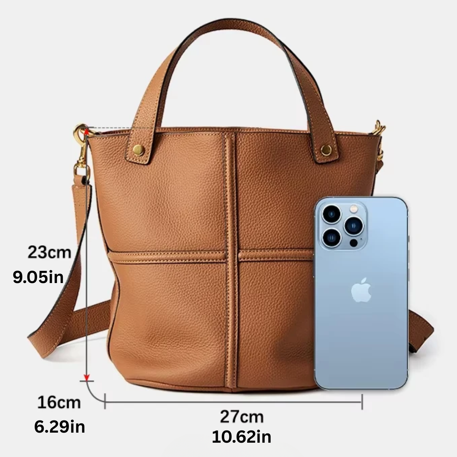 Brown handbag with measurements and an iPhone for scale on a white background