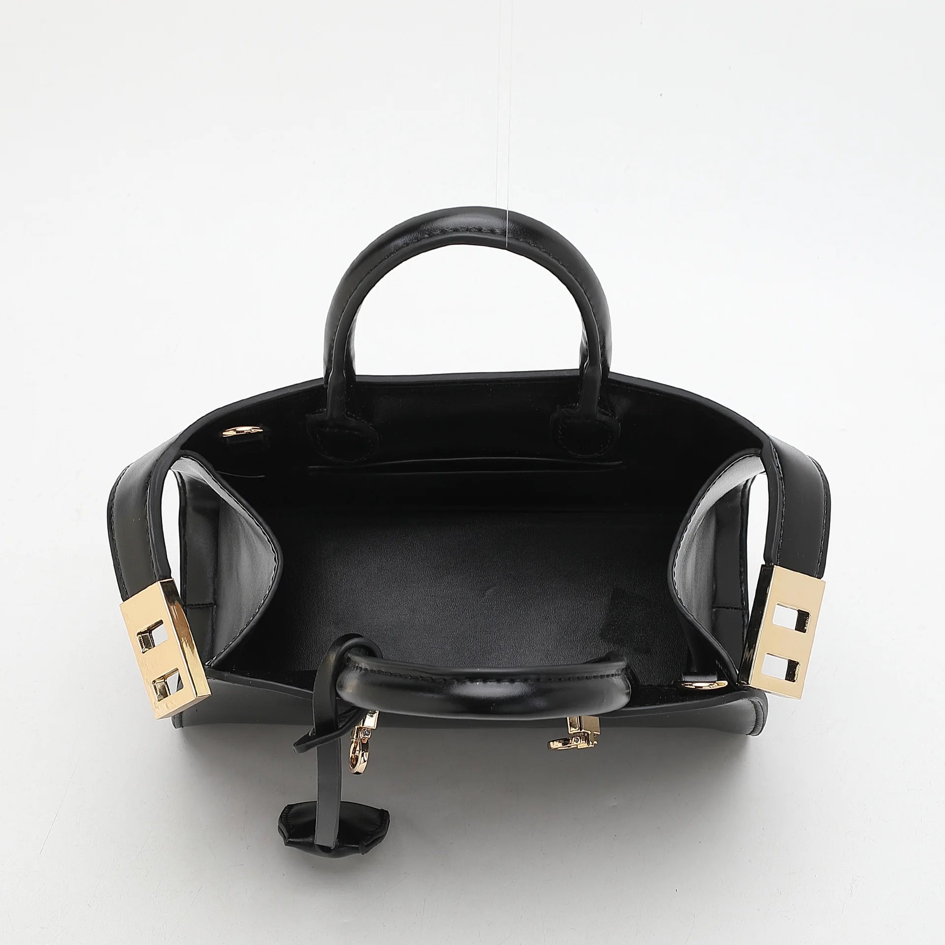 Black handbag with gold accents on a white background