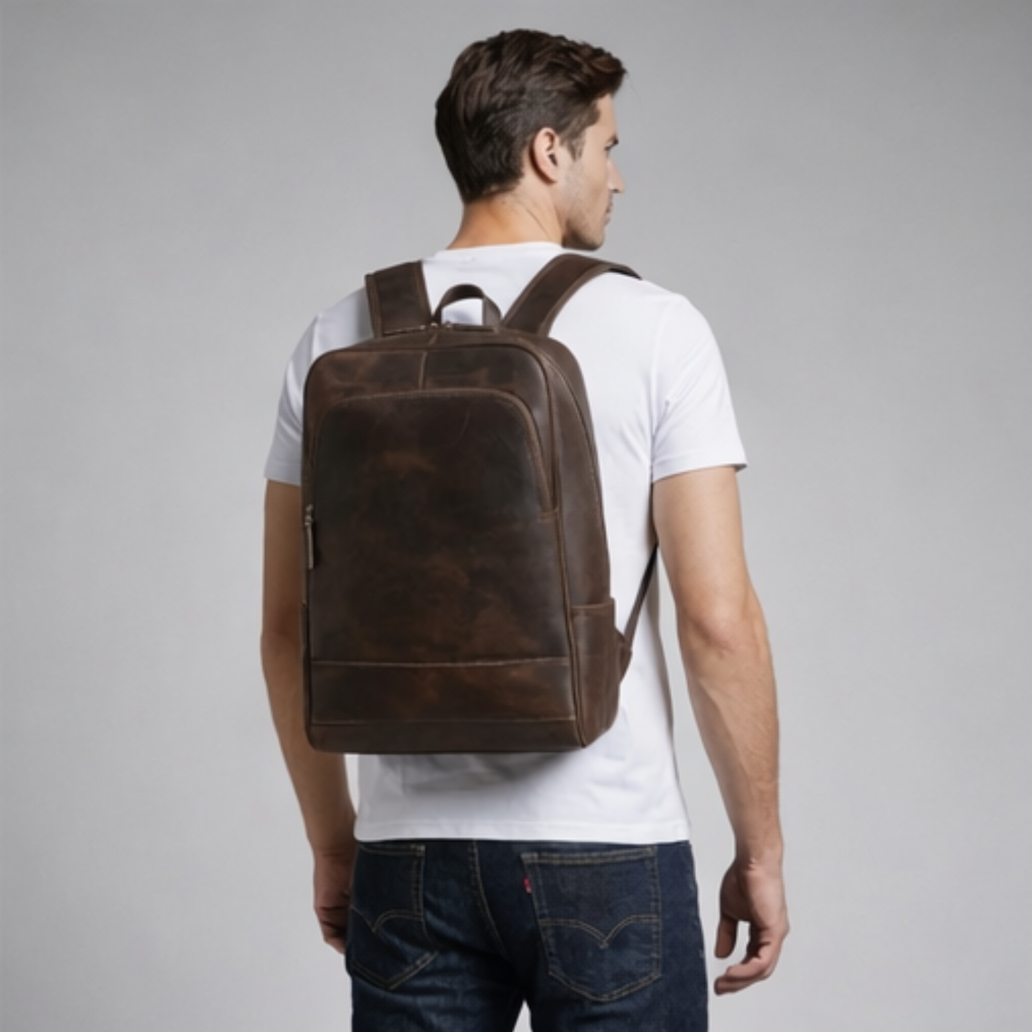 Man wearing a brown leather backpack on a gray background
