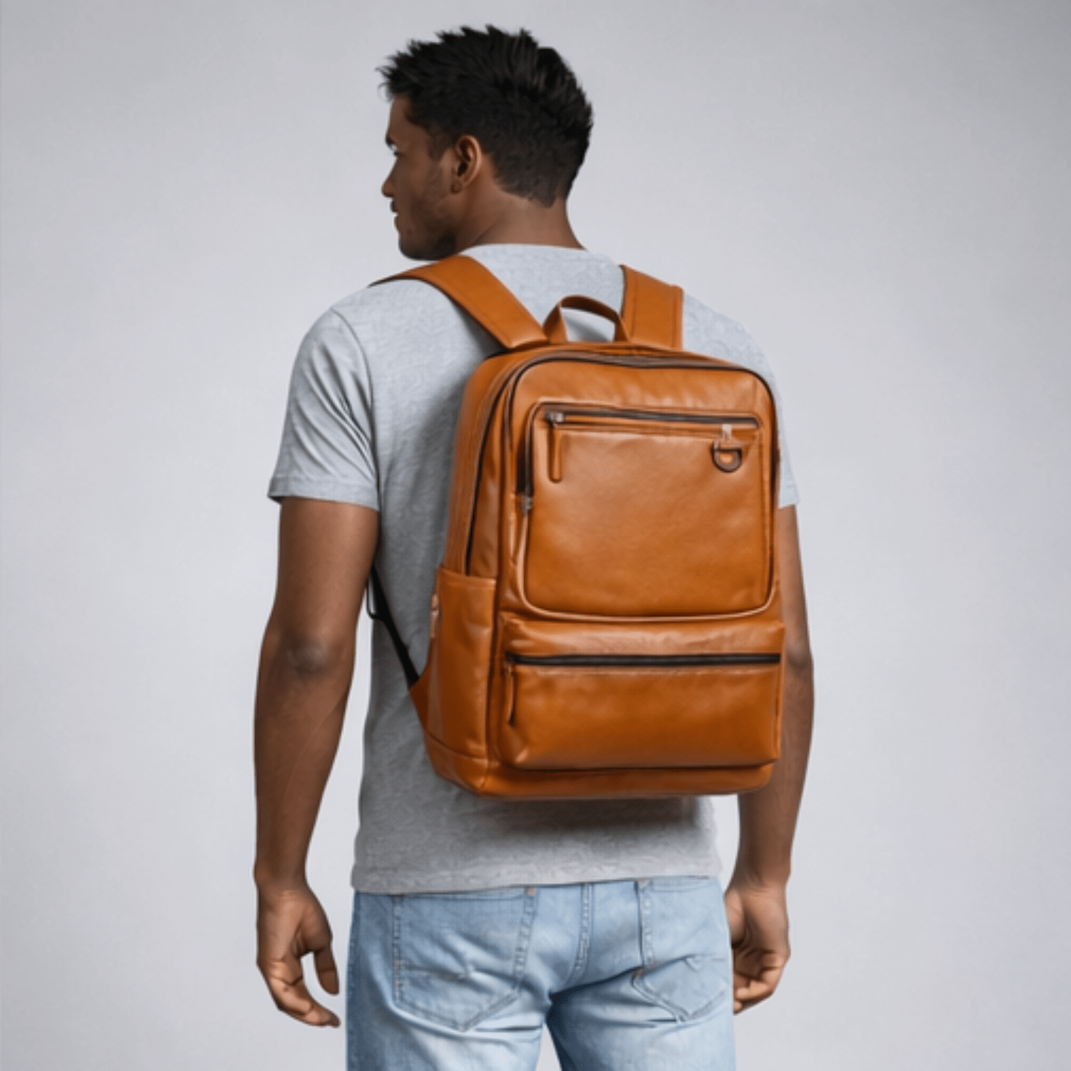 Man wearing a brown leather backpack on a light gray background