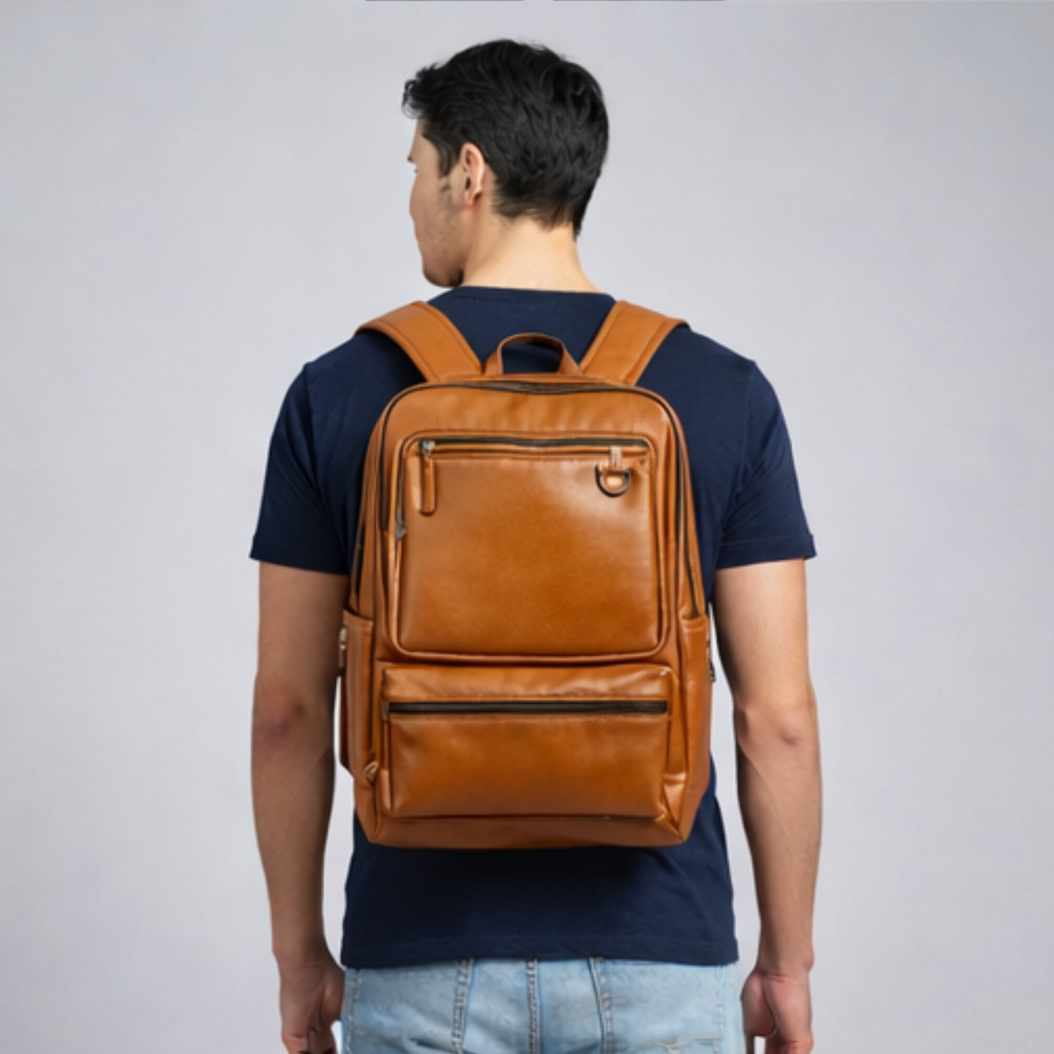 Man wearing a brown leather backpack on a plain background
