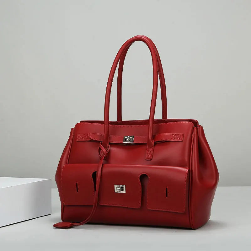 A red luxury genuine leather tote bag with a spacious design, featuring dual handles and a secure lock closure.