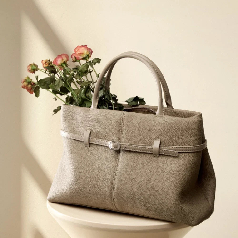 Beige handbag with a floral arrangement on a light background