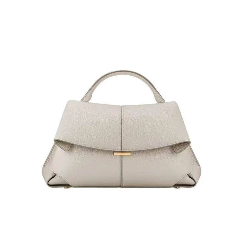 Beige handbag with a gold clasp on a white background