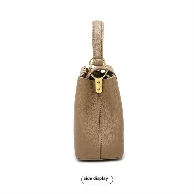 Beige handbag with gold hardware on a white background