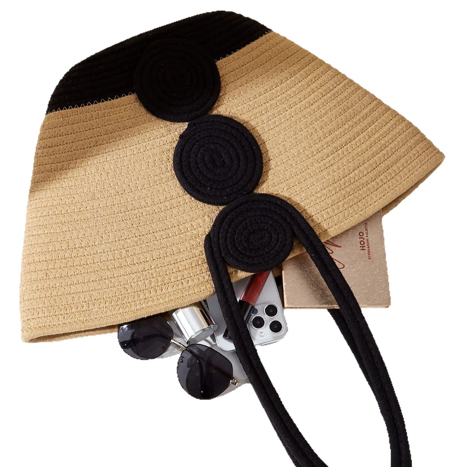 Beige straw hat with black accents and sunglasses on a white background