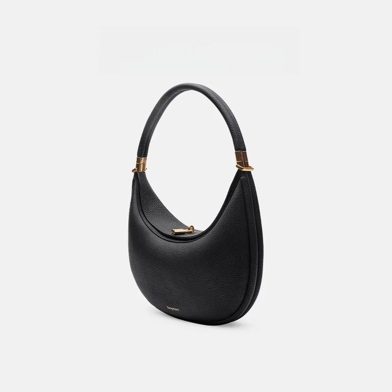 Black handbag with gold accents on a light gray background
