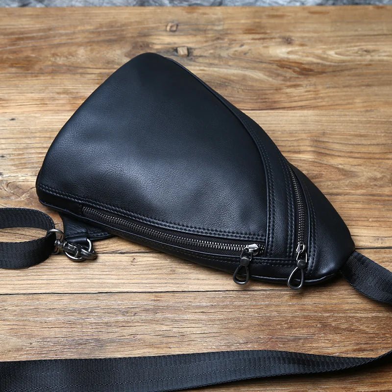 Black leather bag with a zipper on a wooden surface