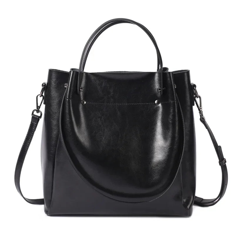 Black leather handbag with a shoulder strap on a white background