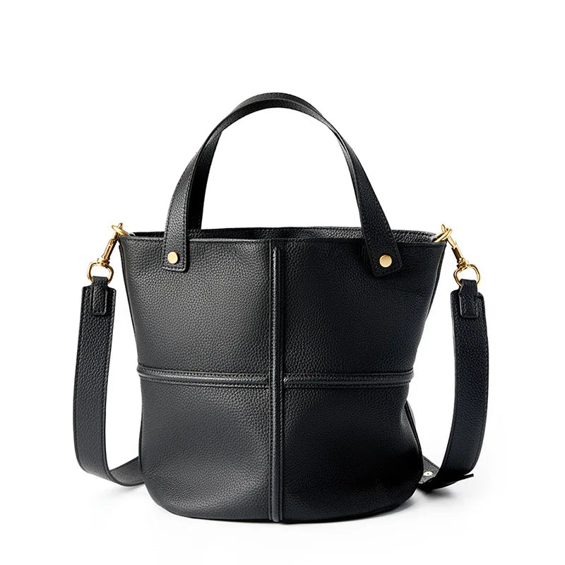 Black leather handbag with gold accents on a white background