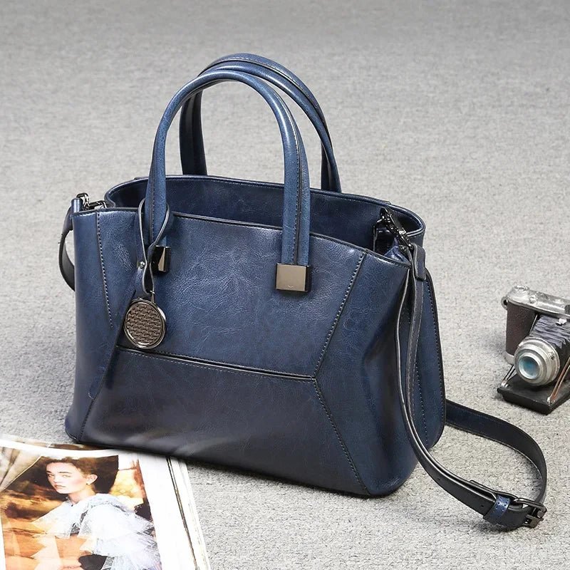 Blue handbag with a camera and photo on a gray surface