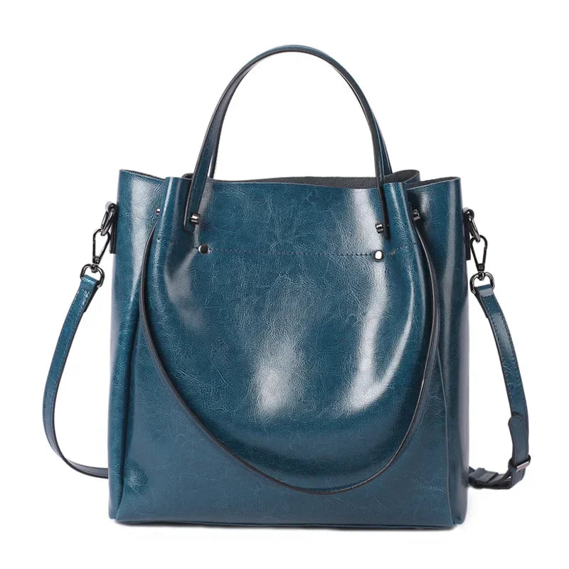 Blue leather handbag with a shoulder strap on a white background