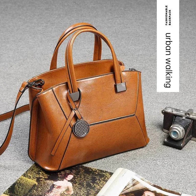 Brown handbag on a gray surface with a camera and magazine underneath, branded 'urban walking'.