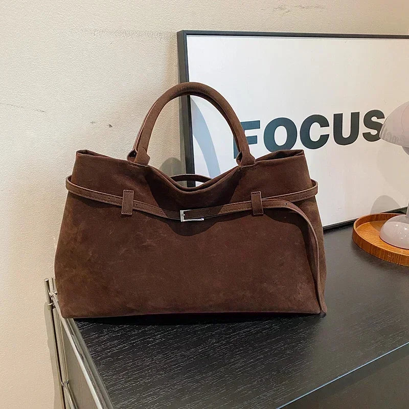 Brown handbag on a reflective surface with 'FOCUS' in the background