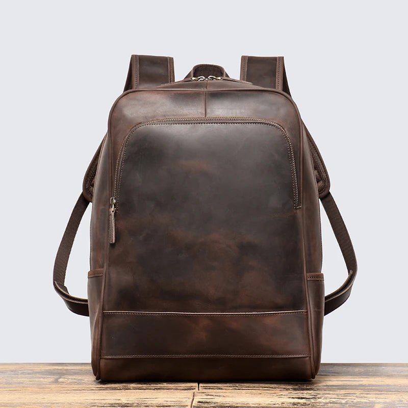 Brown leather backpack on a light gray background