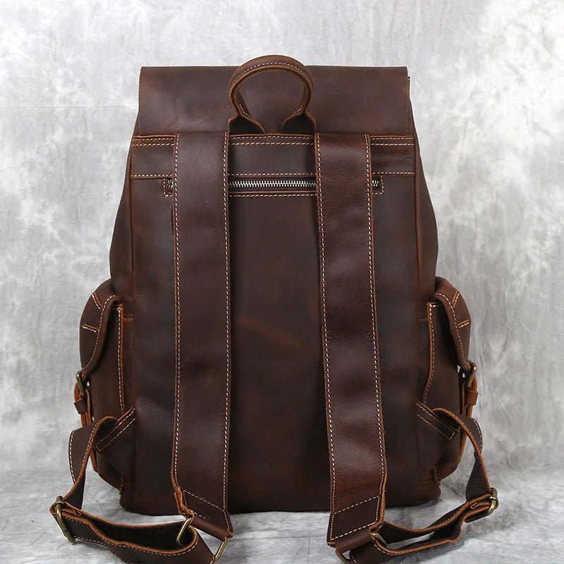 Brown leather backpack on a textured gray background