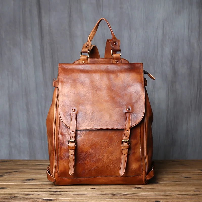 Brown leather backpack on a wooden surface with a gray textured background
