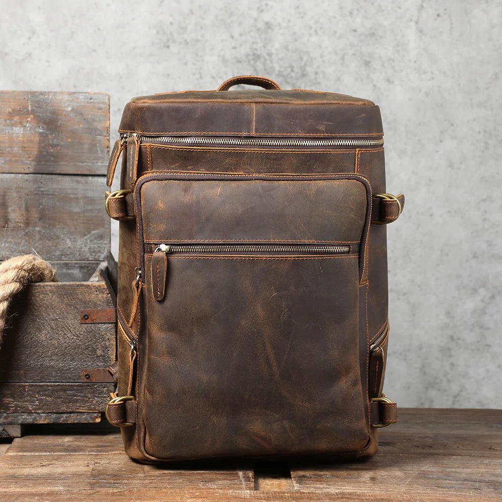 Brown leather backpack on a wooden surface with a rustic background