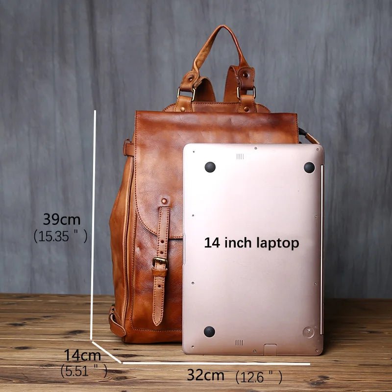 Brown leather backpack with a 14-inch laptop inside, showing dimensions on a wooden surface.