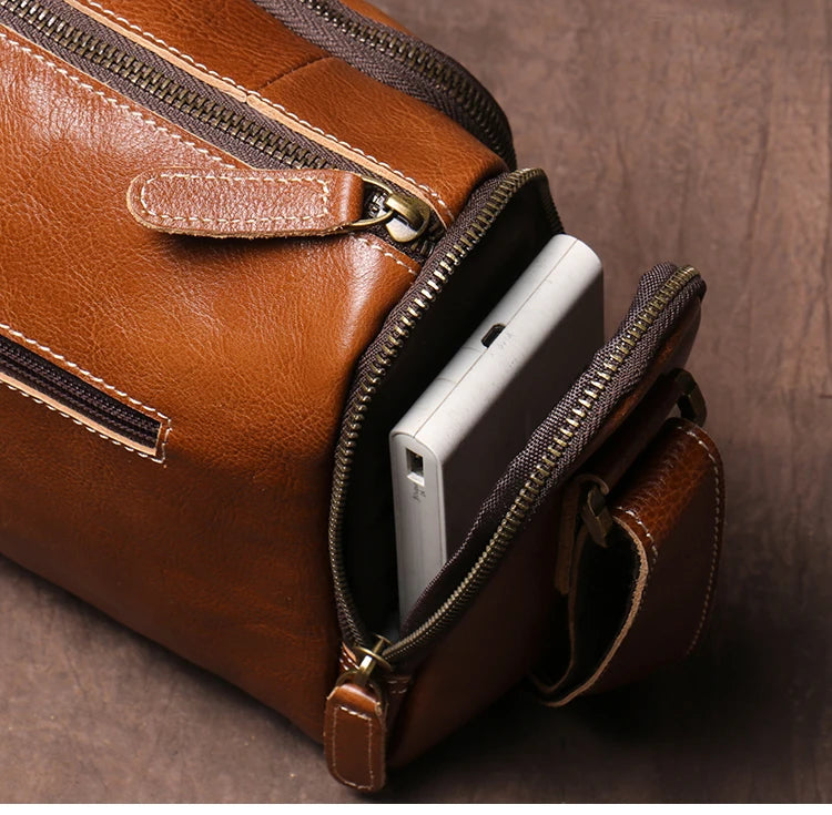 Brown leather bag with a phone inside on a wooden surface