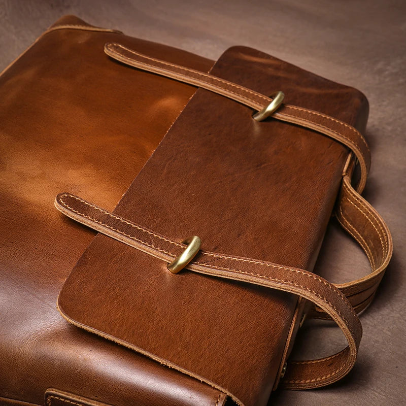 Brown leather bag with gold buckles on a brown background