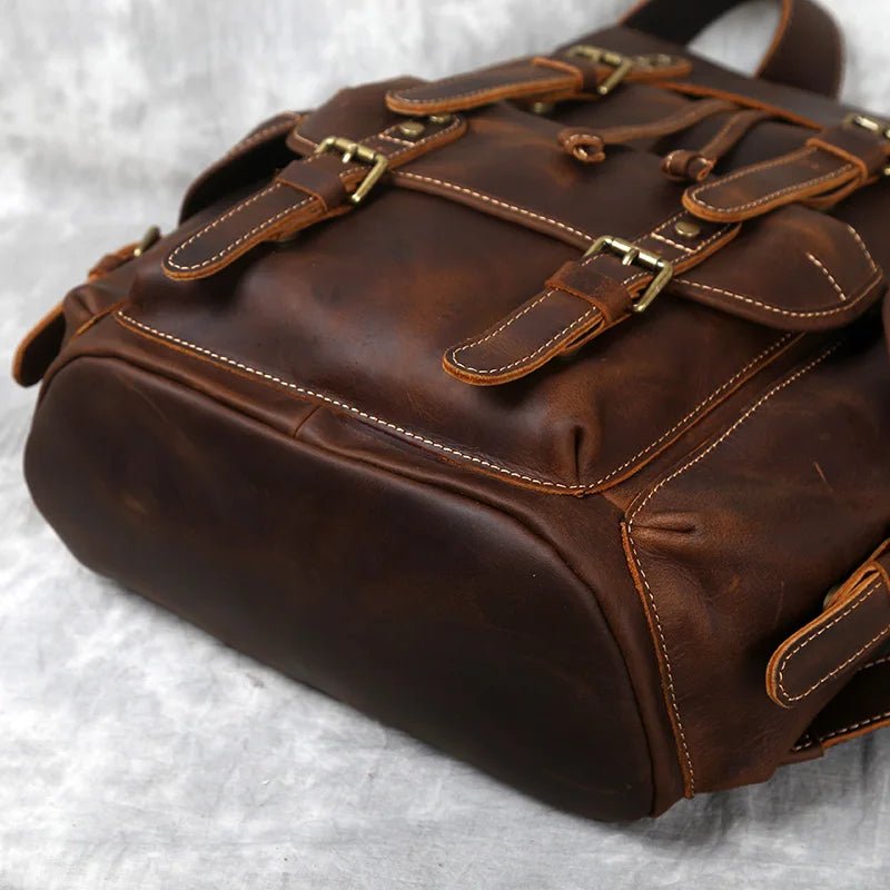 Brown leather bag with gold buckles on a light gray background
