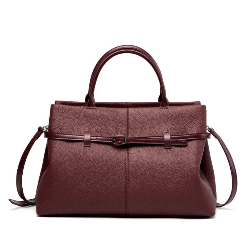 Brown leather handbag with a shoulder strap on a white background