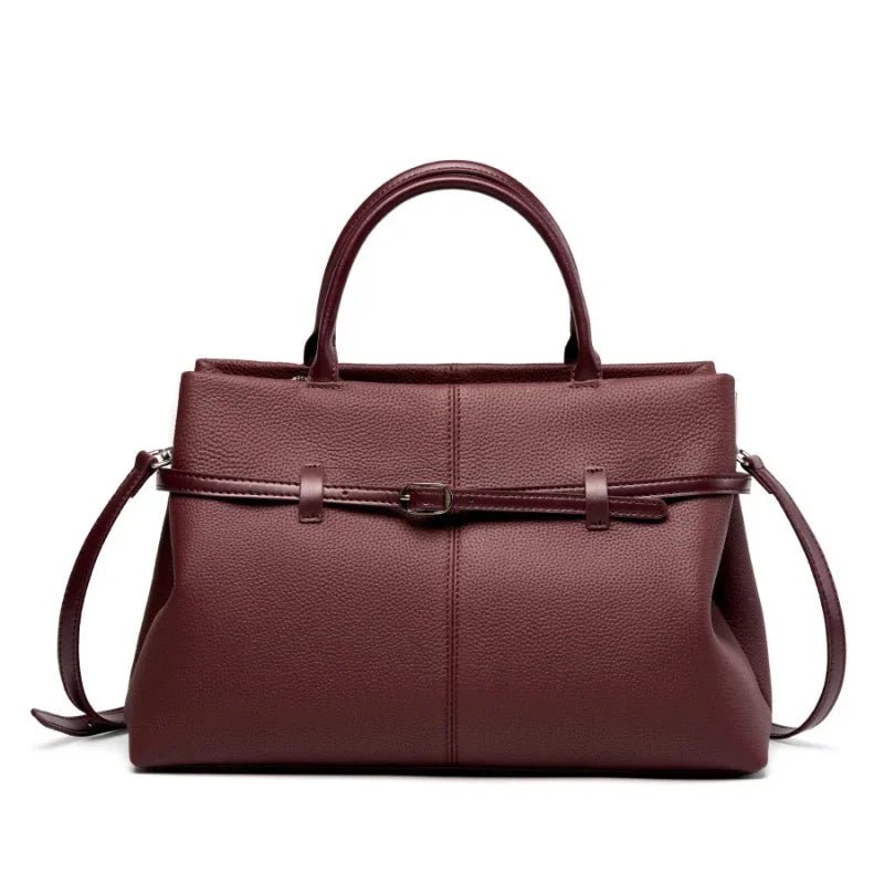 Brown leather handbag with a shoulder strap on a white background