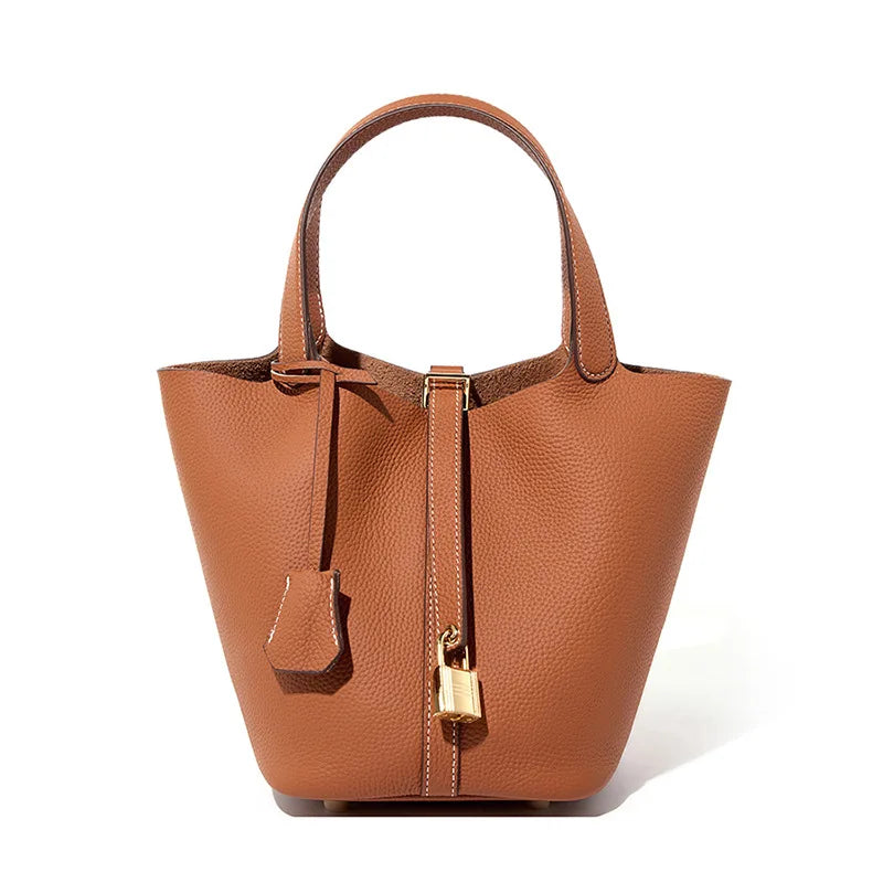 Brown leather handbag with gold accents on a white background