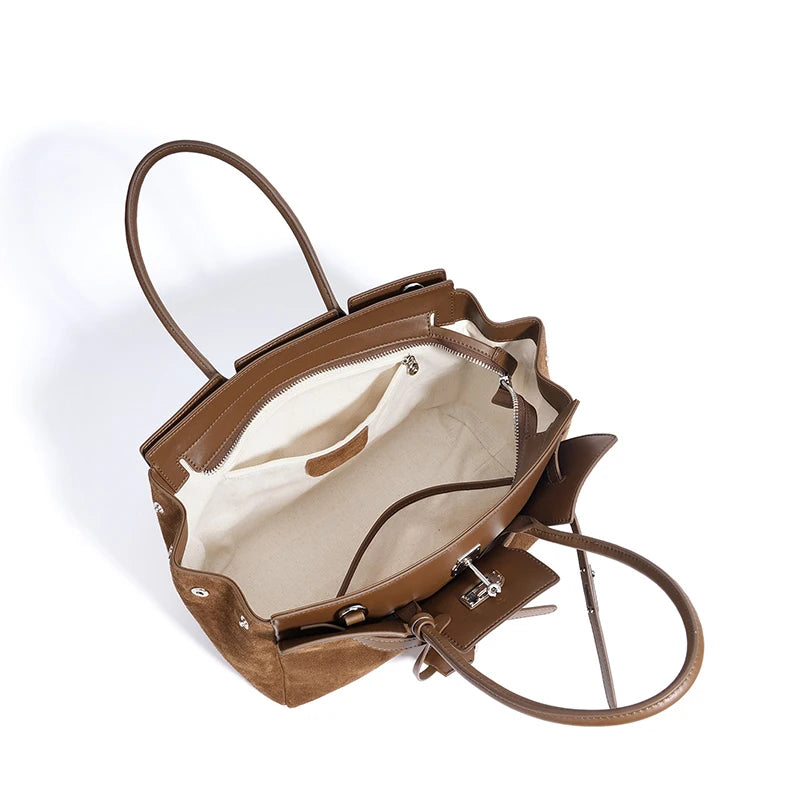 Brown leather handbag with open front pocket on a white background