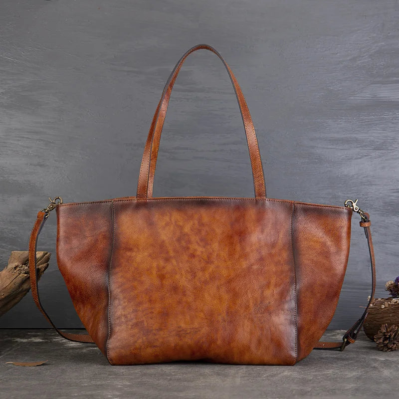 Brown leather tote bag on a gray background