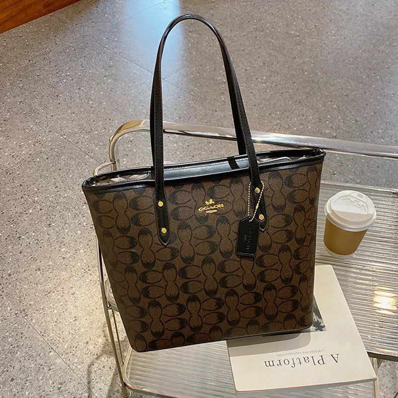 Coach handbag with a coffee cup on a glass table