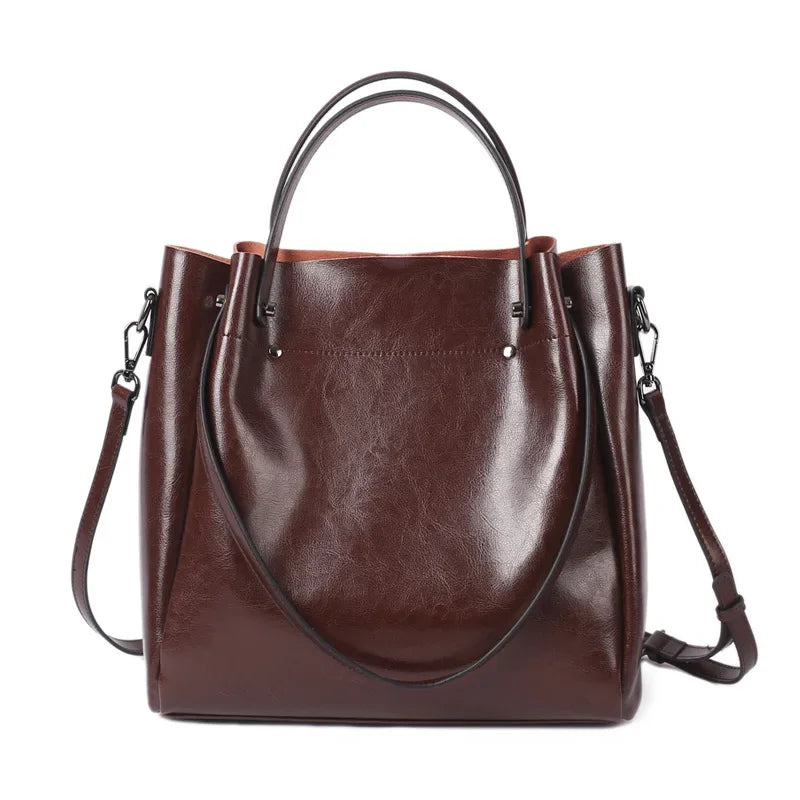 Brown leather handbag with a shoulder strap on a white background