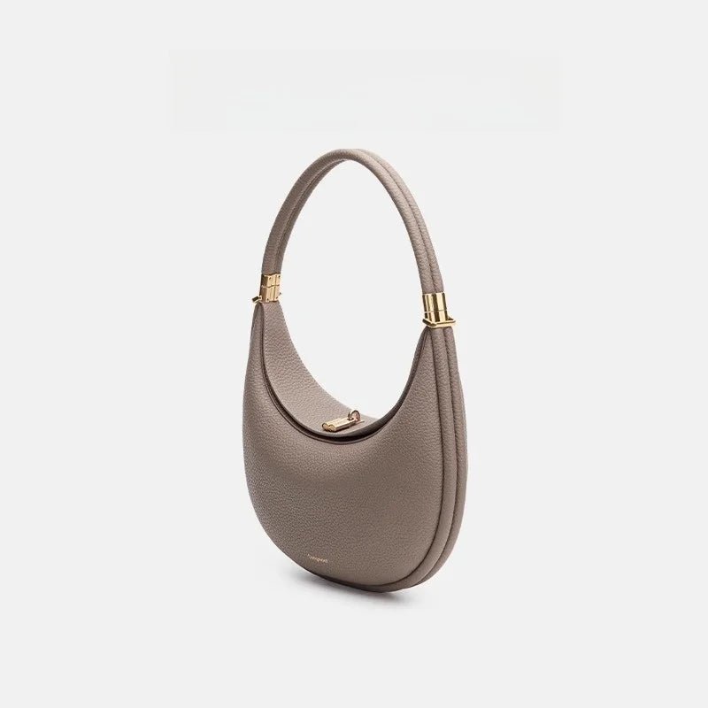 Gray handbag with gold accents on a light gray background