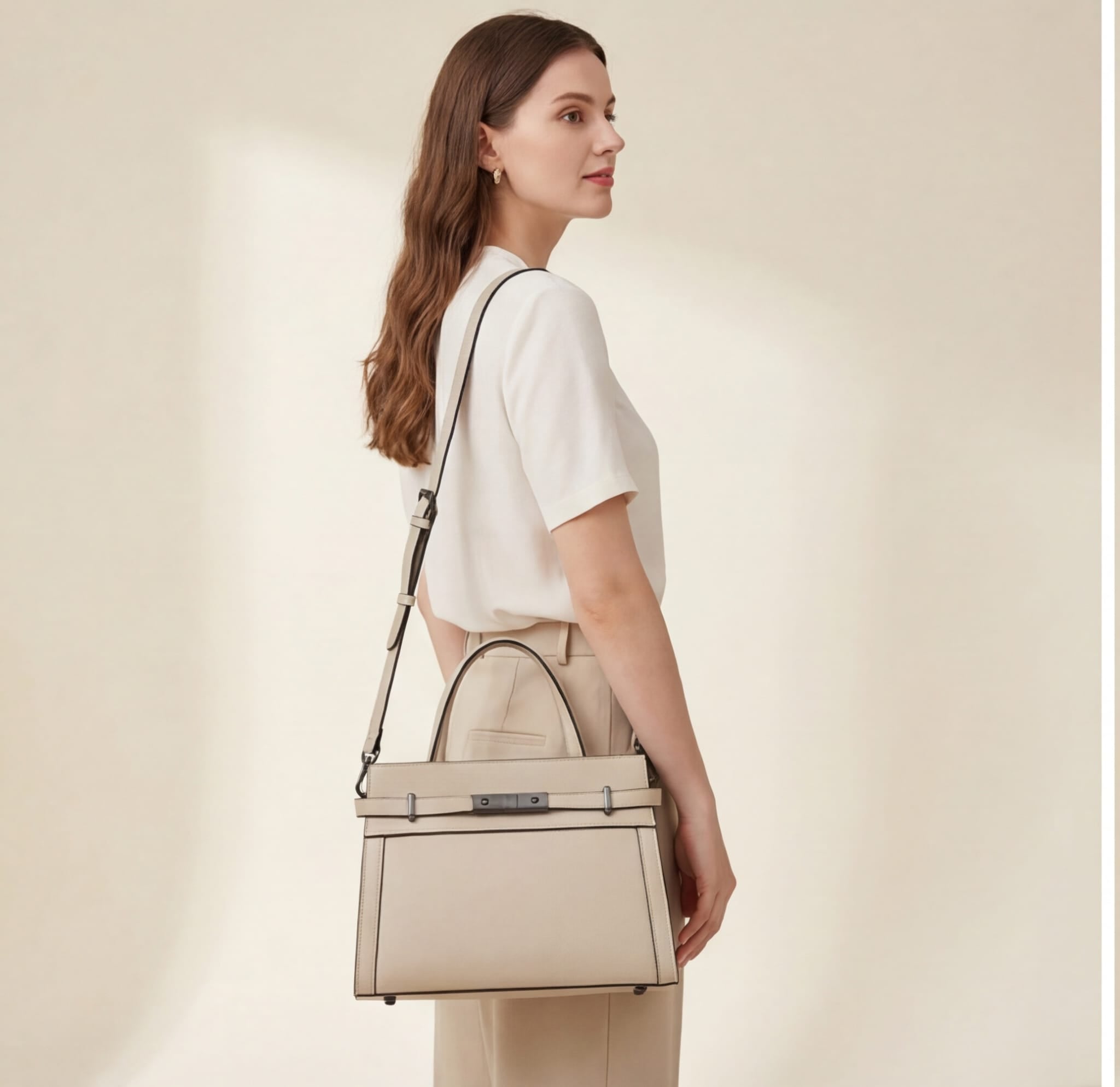 Woman carrying a beige handbag against a plain background