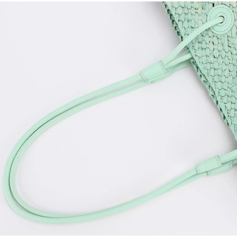 Mint green woven bag with matching strap on a light gray background