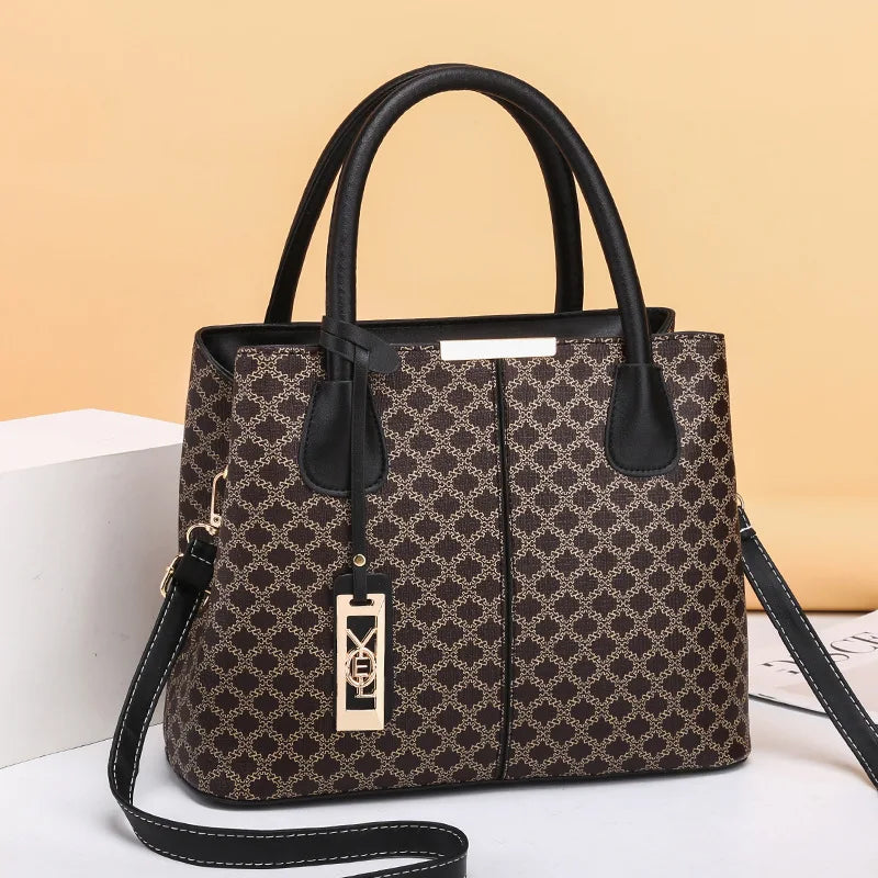 Patterned handbag with black handles and strap on a beige background