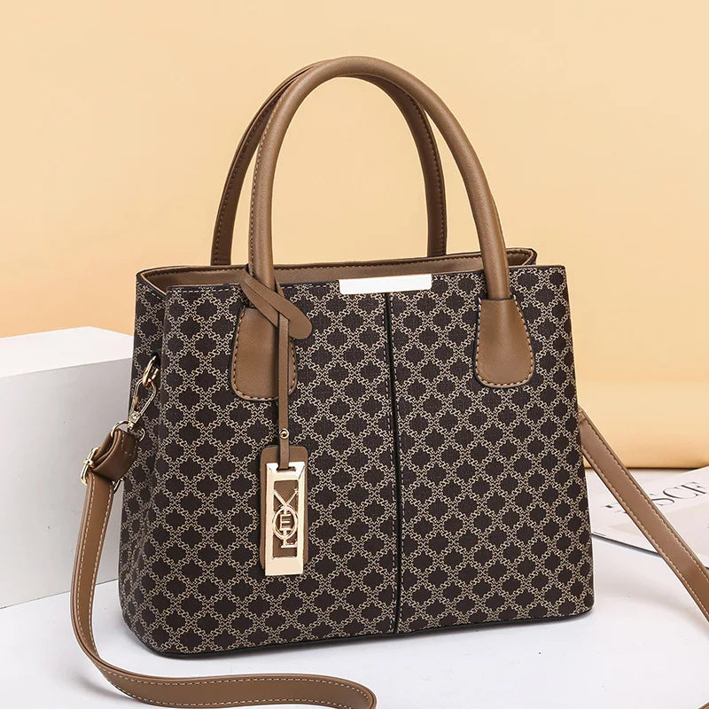 Patterned handbag with brown handles and strap on a light background