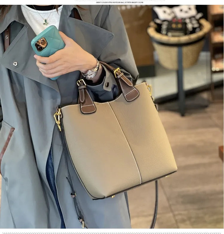Person holding a beige handbag with a blurred indoor background