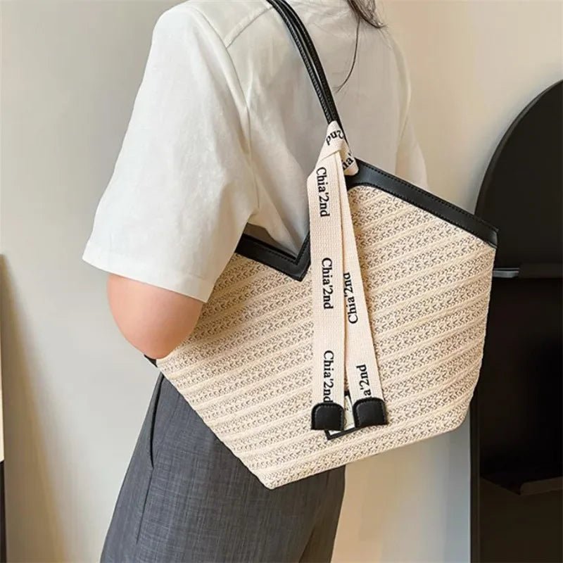 Person holding a patterned tote bag with visible branding against a neutral background