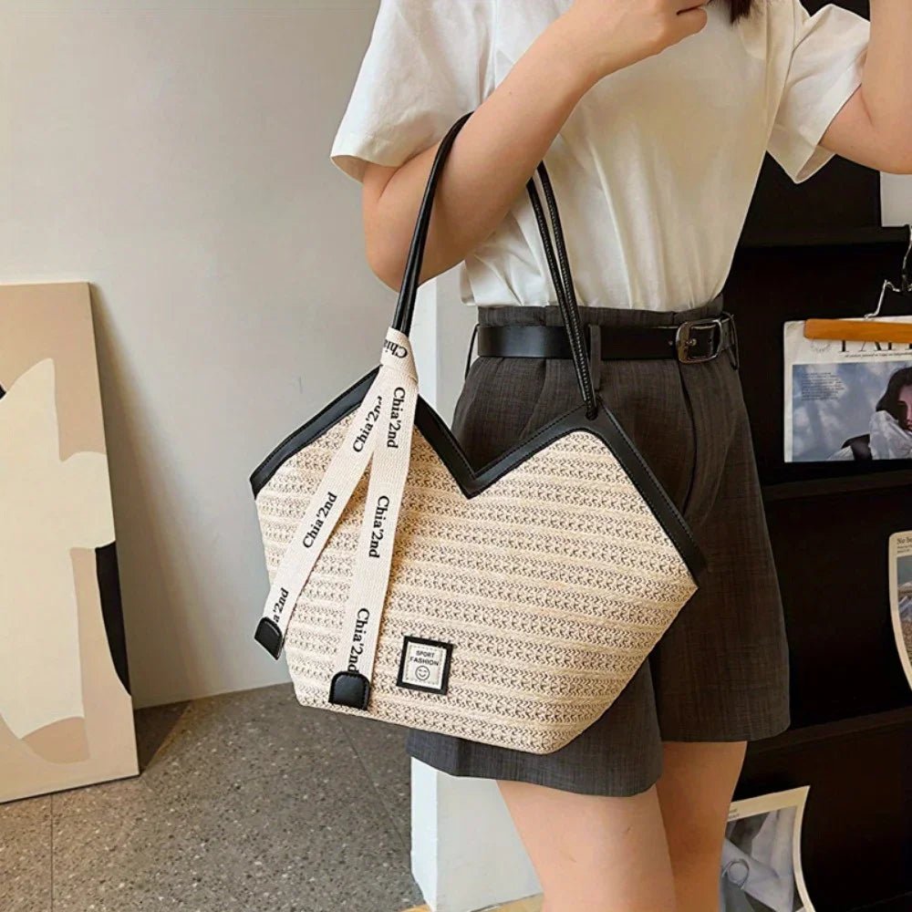 Person holding a woven handbag with a plain background