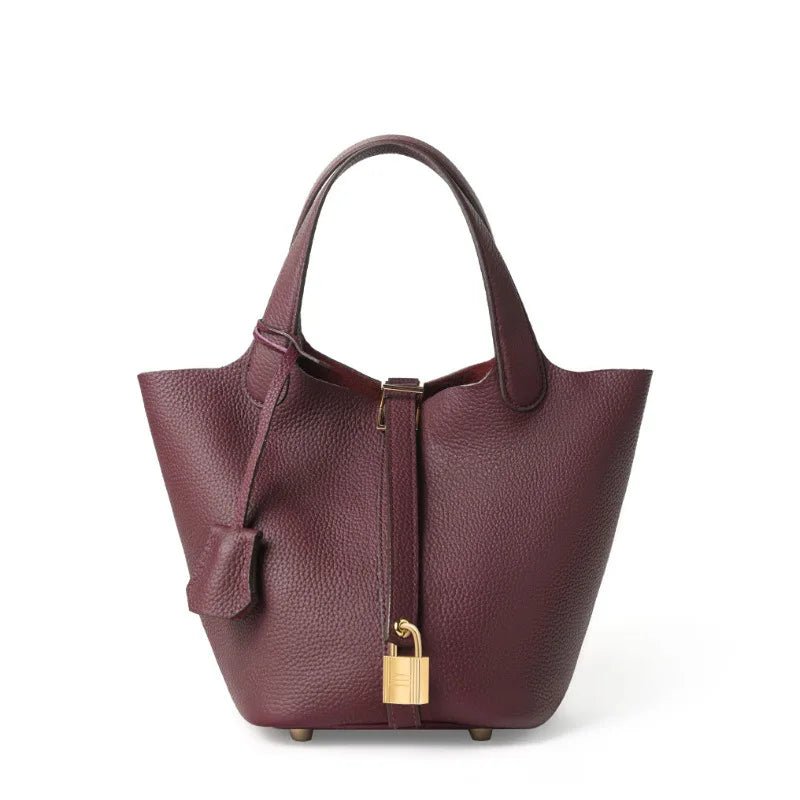 Purple handbag with a gold lock on a white background