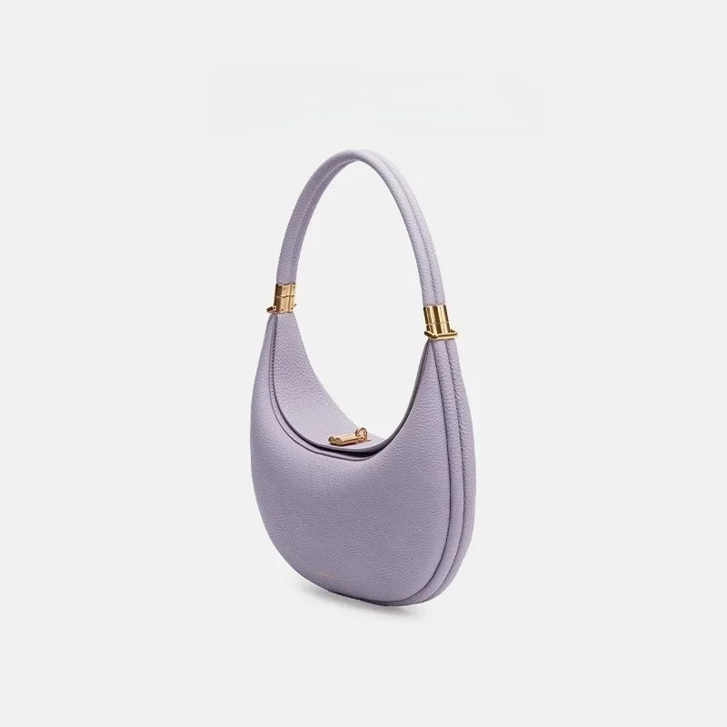 Purple handbag with gold accents on a light gray background