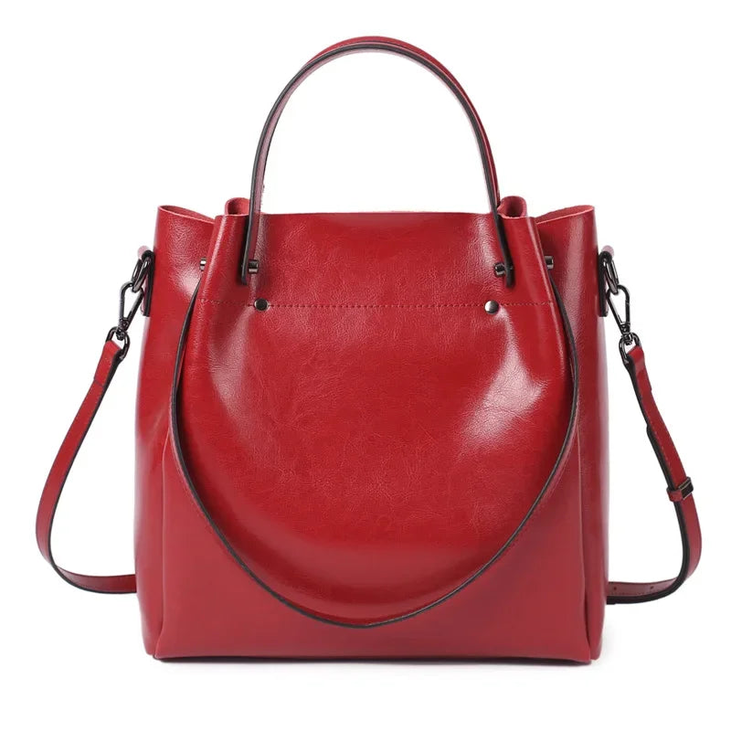 Red leather handbag with a shoulder strap on a white background