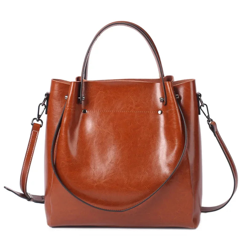 Brown leather handbag with a shoulder strap on a white background