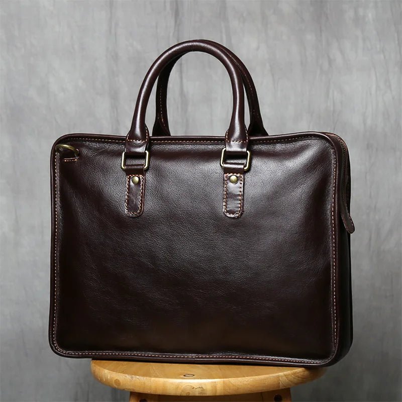 Brown leather briefcase on a wooden stool against a gray background