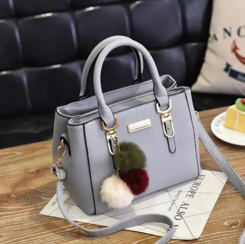 Elegante weinrote Tragetasche mit Pom-Pom-Anhänger